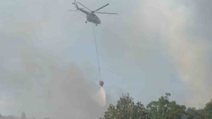 Kontrol altına alınan yangına helikopterler ile müdahale ediliyor
